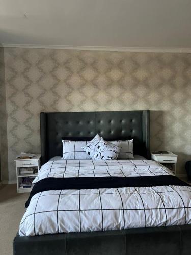 a bedroom with a large bed and two night stands at Sleep easy at Peperboom in Kuilsrivier