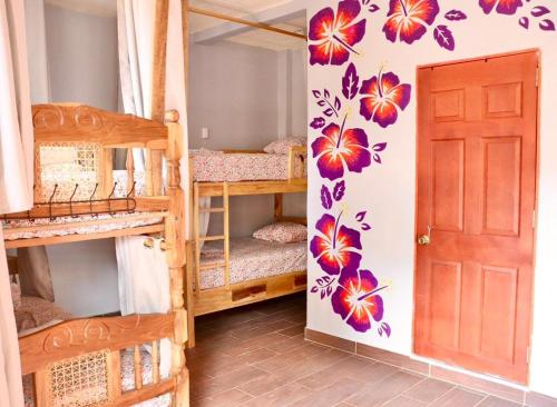 een kamer met meerdere stapelbedden en een deur bij The Salty Dogs in Playa San Blas