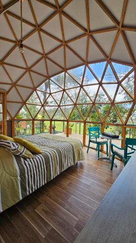 a large tent with a bed and chairs in a room at Glamping Reserva del Dorado in Sesquilé