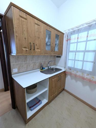 a kitchen with wooden cabinets and a sink and a window at Casa Los Tilos 3 in Los Sauces