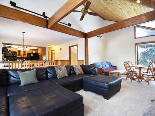 a living room with a black leather couch and a table at 61 Jabberwocky Home by Stay Winter Park in Fraser
