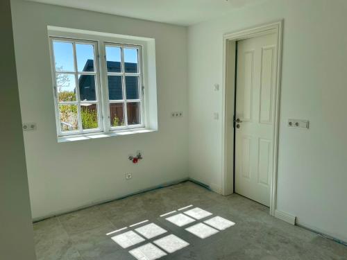 una stanza vuota con finestra e porta di Sommergeest a Goting