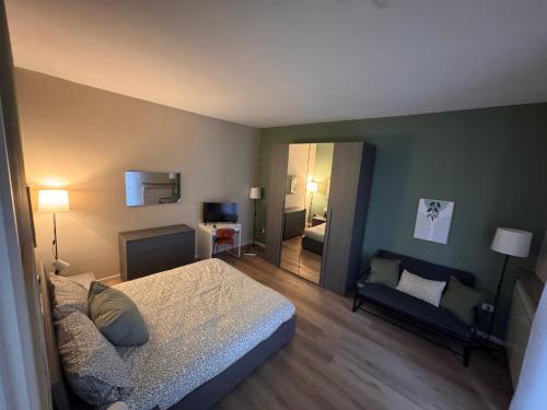 une chambre avec un lit, un canapé et un miroir dans l'établissement Le due dimore di Corso Torino, à Novara