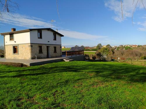 una casa in mezzo a un campo verde di La Tadorna a Suances