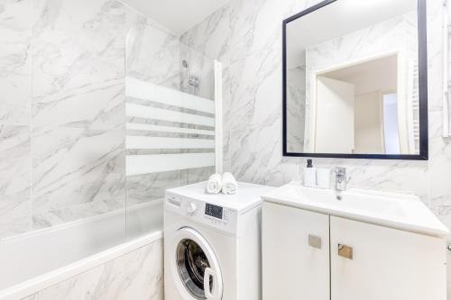 a white bathroom with a washing machine and a sink at Cinéhouse, Proche Paris 5 min, 2 chambre in Bobigny