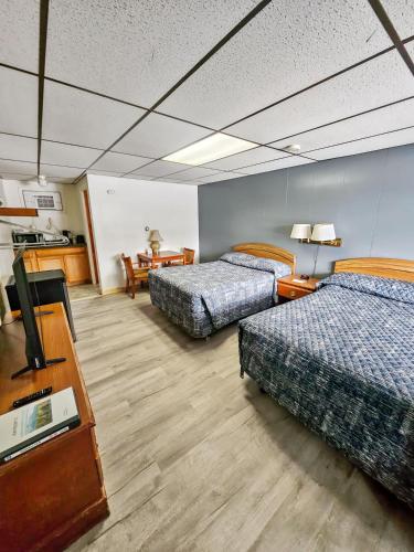 una camera d'albergo con due letti e una televisione di Katahdin Valley Motel 