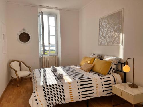 una camera da letto con un letto con cuscini gialli e una finestra di Ancien Château viticole a Bourg-sur-Gironde