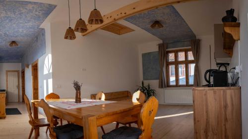 a dining room with a wooden table and chairs at Curte la Munte - charming village house in Sebeşu de Sus