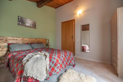 a bedroom with a bed with a wooden headboard at Rustic Italian House in Roccamorice