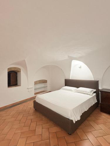 een slaapkamer met een bed in een kamer met bogen bij DIMORA MedioEvo in Orvieto