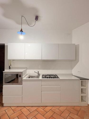 een witte keuken met een spoelbak en een fornuis bij DIMORA MedioEvo in Orvieto