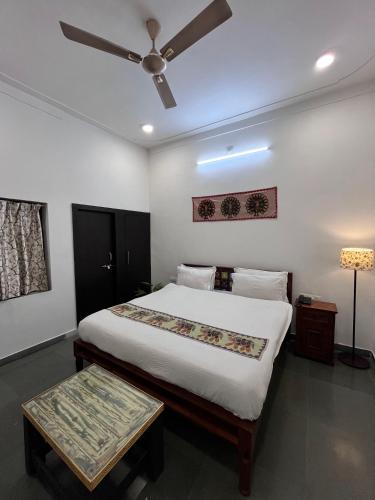 a bedroom with a bed and a ceiling fan at Riga House in Udaipur