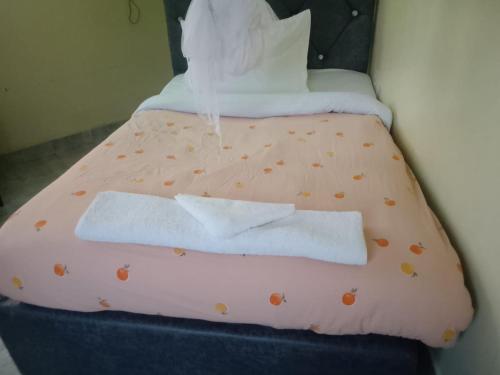 een bed met oranje lakens en kussens met stippen bij Atlantis City BnB in Nakuru