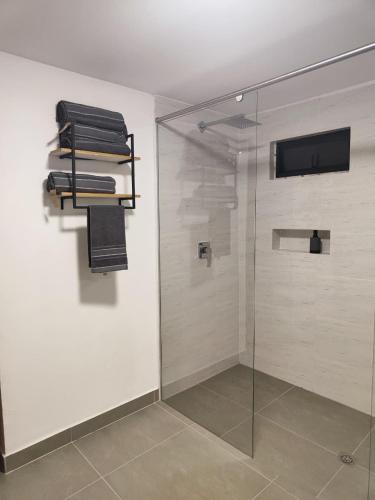 a bathroom with a shower with a glass door at Hotel La Casona - Cerca al Estadio Atanasio Girardot y Laureles in Medellín