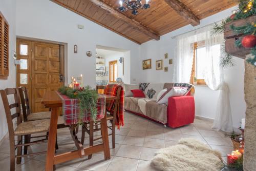 een woonkamer met een tafel en een bank bij Rustic Italian House in Roccamorice
