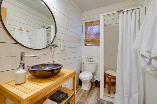 un bagno con lavandino, specchio e WC di Waterfront Deck! Chic Lower Scott Lake Cottage a Pullman