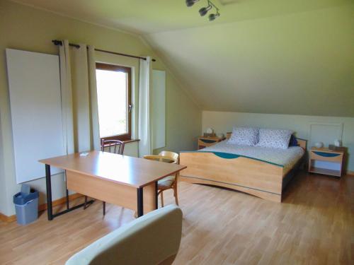 1 dormitorio con cama, escritorio y mesa en BnB Heimdall, en Brecht