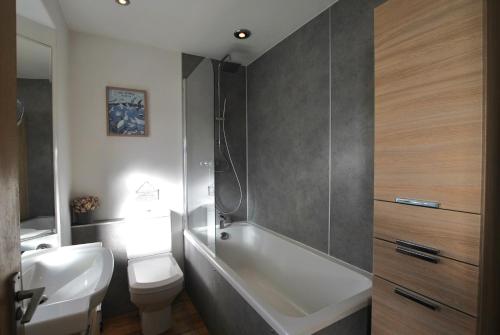 a bathroom with a tub and a toilet and a sink at Mill View Cottage- charming coastal cottage in Saint Monance
