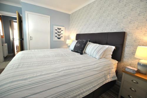 a bedroom with a bed and a brick wall at Mill View Cottage- charming coastal cottage in Saint Monance