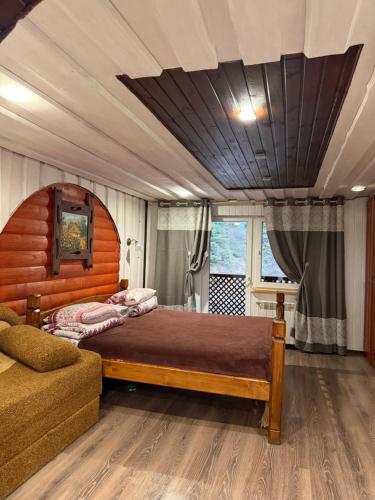 een slaapkamer met een groot bed en een bank bij У Віти номер 4 in Synevyrsʼka Polyana