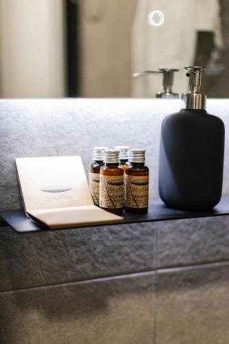 three jars of honey sitting on a counter next to a sink at Astor Wellness apartman in Belgrade