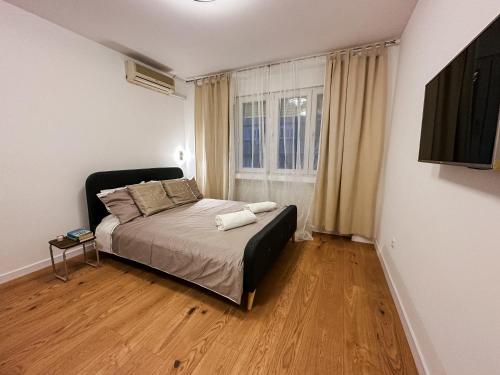 a bedroom with a bed and a large window at Astor Wellness apartman in Belgrade