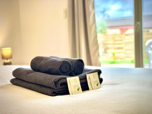 een stapel handdoeken bovenop een bed bij " Au coin du Lys " Garage - Jardin - Wifi in Saint-Lys