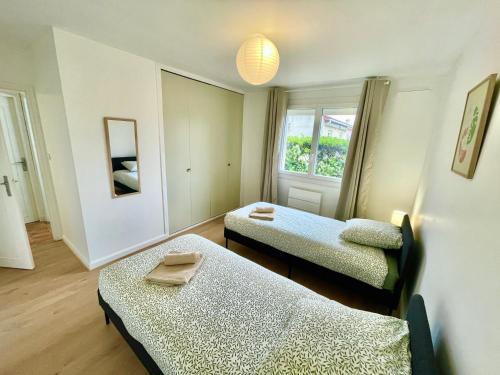 een kamer met twee bedden en een raam bij " Au coin du Lys " Garage - Jardin - Wifi in Saint-Lys