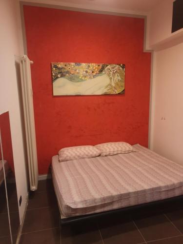 een slaapkamer met een bed met een rode muur bij Mini Hostel 404 in Turijn
