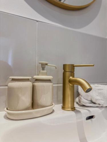 a bathroom sink with a soap dispenser and a faucet at Liberté Prestige - Tram - Rocade in Fontaine