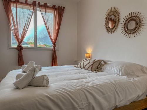 a white bed with two stuffed animals on top of it at Liberté Prestige - Tram - Rocade in Fontaine