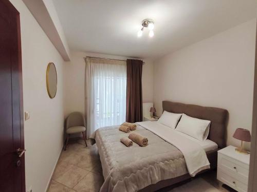 a bedroom with a large bed with two teddy bears on it at PERLA apartment in Alexandroupoli