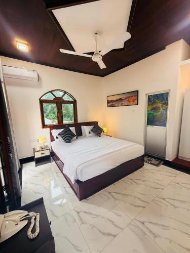 a bedroom with a bed and a ceiling fan at New Star Villa in Bentota