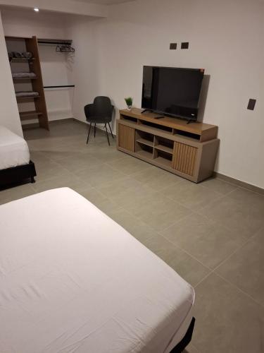 una camera da letto con un letto e una TV a schermo piatto di Hotel La Casona Estadio a Medellín