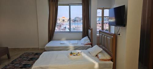 a hotel room with two beds and a television at Morsy Palace in Luxor
