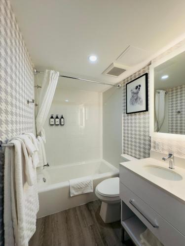 a bathroom with a tub and a toilet and a sink at Quality Inn & Suites Thunder Bay Downtown in Thunder Bay