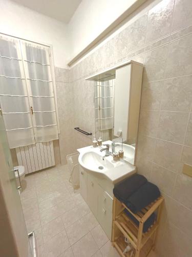 a white bathroom with a sink and a mirror at Home Sweet Home Forli in Forlì