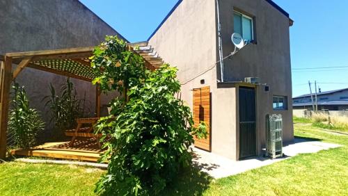 ein Haus mit einem großen grünen Busch davor in der Unterkunft Casa vacacional LUNA DE MAR in Santa Clara del Mar