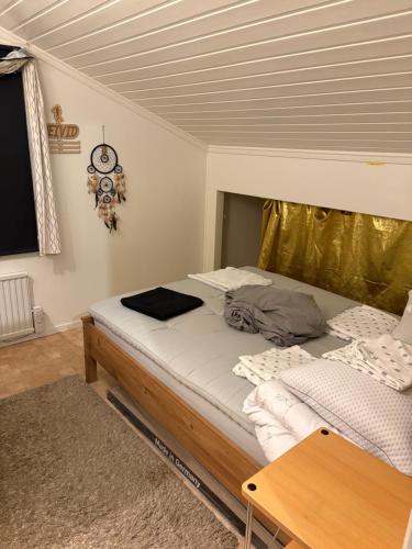 a bed in a room with a wooden ceiling at Mysigt boende med bastu och kamin in Strömstad