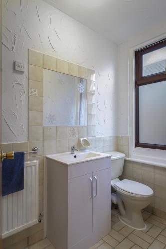 a white bathroom with a toilet and a sink at Royal Oakwell Hotel in Blackpool