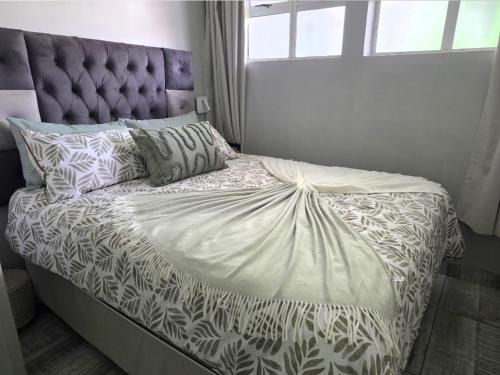 a bedroom with a bed with a tufted headboard at DURBAN BEACHFRONT Tenbury 903 in Durban