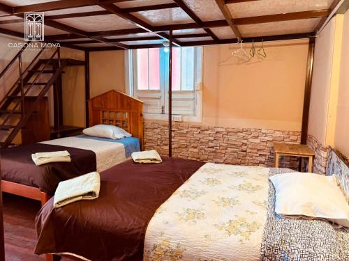 2 Betten in einem Zimmer mit einer Treppe in der Unterkunft Casona Moya in Arequipa