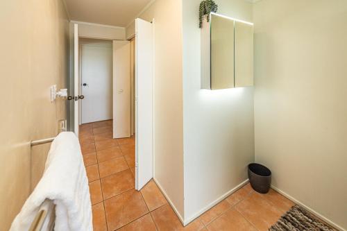 a bathroom with a white cabinet and a tile floor at Hillside Haven in Whanganui