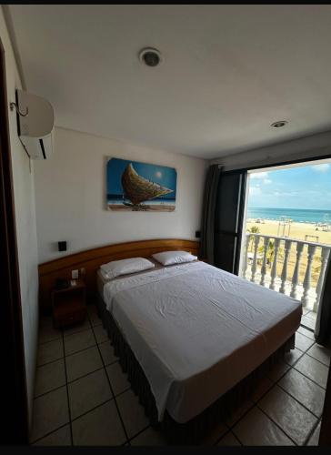 una camera da letto con un letto e una grande finestra di Classic Flat a Fortaleza