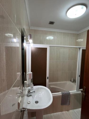 a bathroom with a sink and a bath tub at Casa Do Arco - Machico Centre with Private Balconies and Parking in Machico