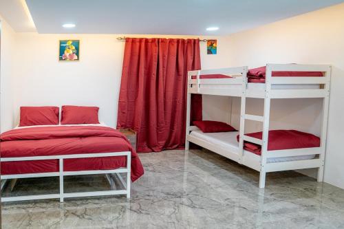 - une chambre avec 2 lits superposés et un rideau rouge dans l'établissement Eco Paradise UAQ Harmony with Nature, à Umm Al Quwain
