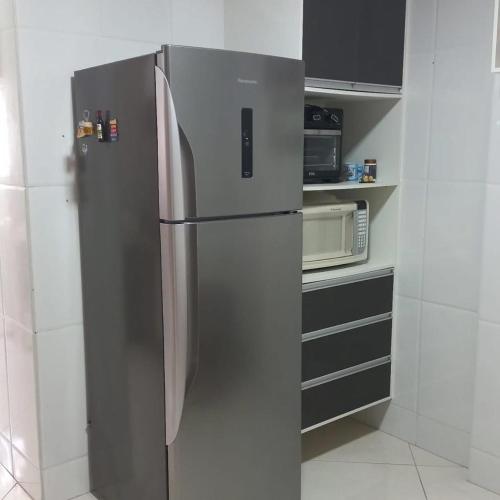 un frigorifero in acciaio inossidabile in una cucina con forno a microonde di Apartamento Beira-mar a Guarapari