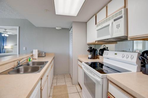 基韦斯特The Barbados - Sunrise Suites的厨房里有水槽和炉灶。 上层烤箱