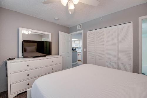 基韦斯特The Barbados - Sunrise Suites的卧室里有一张白色的床和一台平板电视