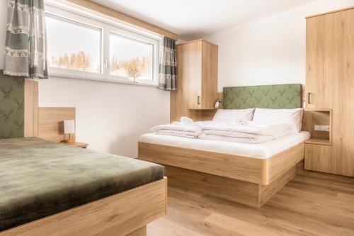 a bedroom with two beds and a window at Peterlehen Appartements in Altenmarkt im Pongau
